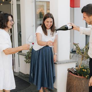 Familie Krutzler trinkt Sekt vorm Hotel.