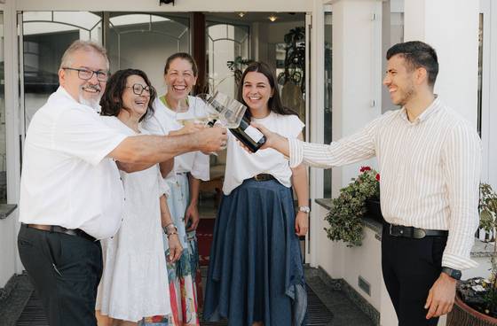 Familie Krutzler trinkt Sekt vorm Hotel.