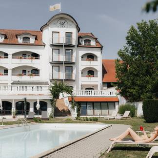Dame auf einer Liege am Pool.
